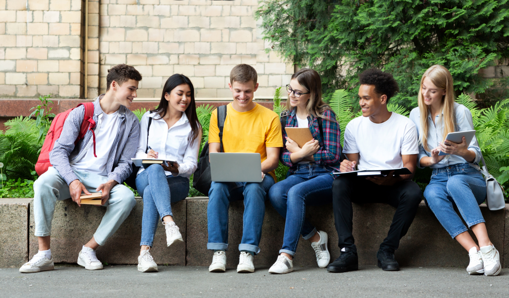 Happy teens preparing for exams in university campus 